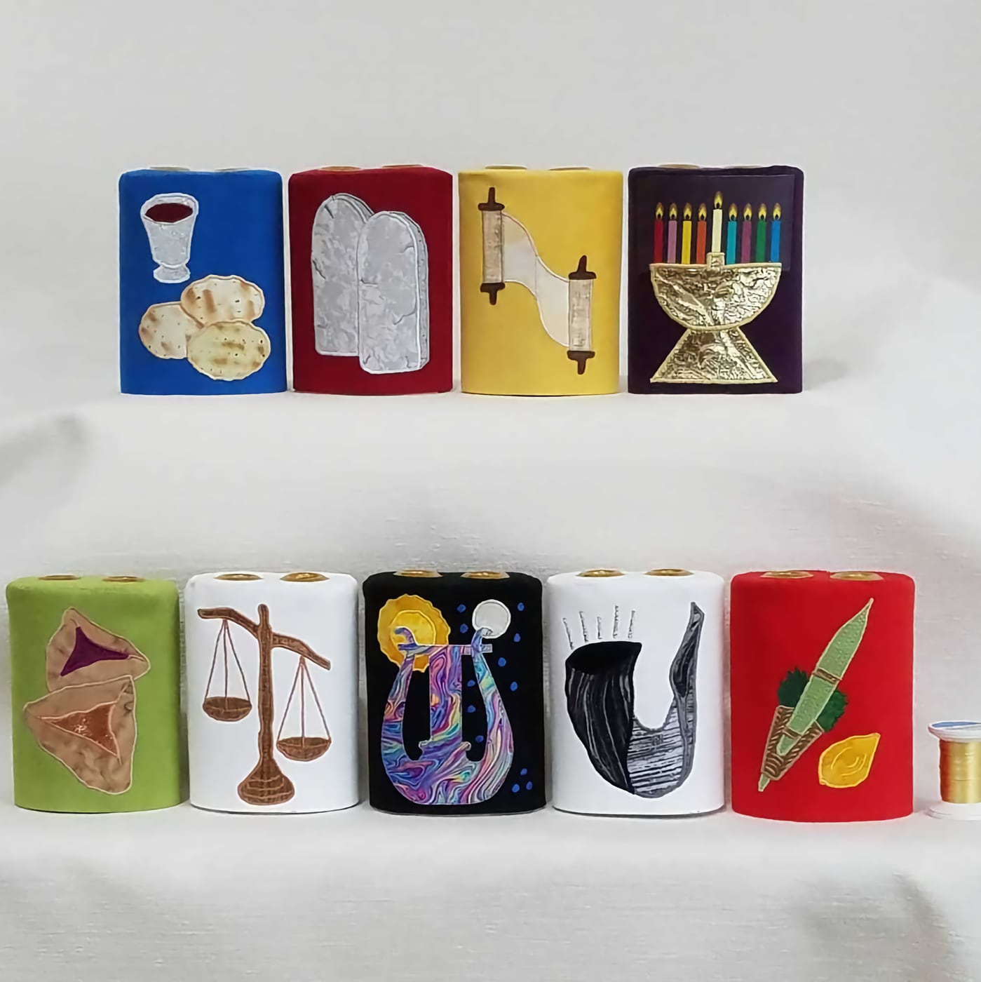 a set of colorful miniature torah covers
