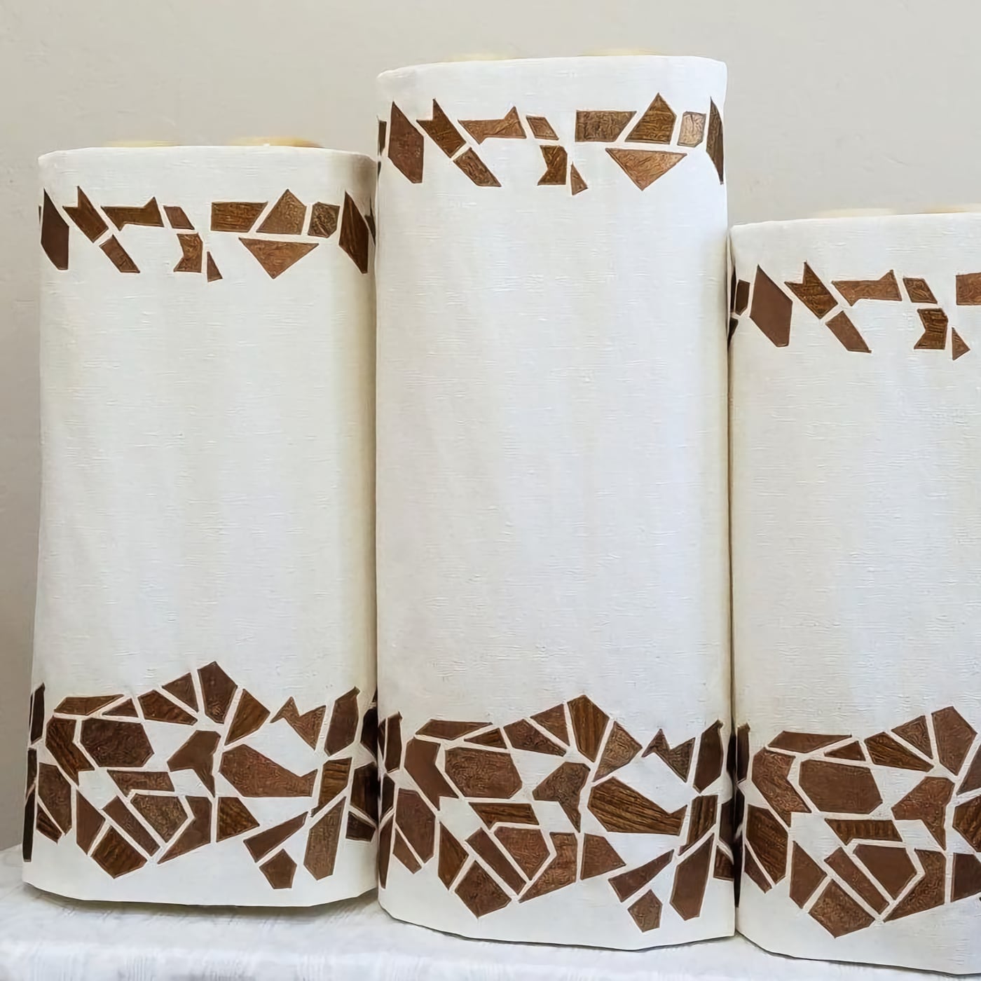a set of white torah covers with shards decorations